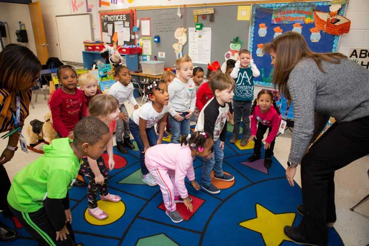 Young children moving and jumping in the classroom.